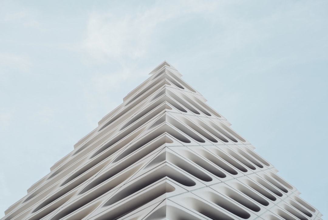 A white triangular building with parametric patterns against the sky in a closeup, high resolution, super detailed, cinematic photographic style. –ar 64:43