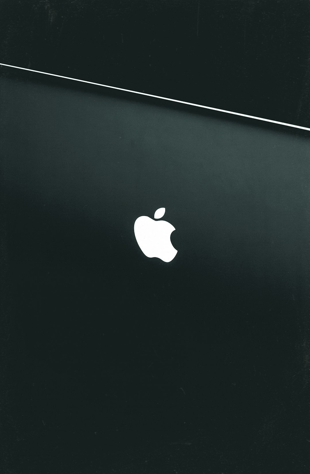 minimalist black wallpaper, apple macbook pro with the white logo on it, flat, minimal, black and white, high contrast, simple, grainy –ar 83:128