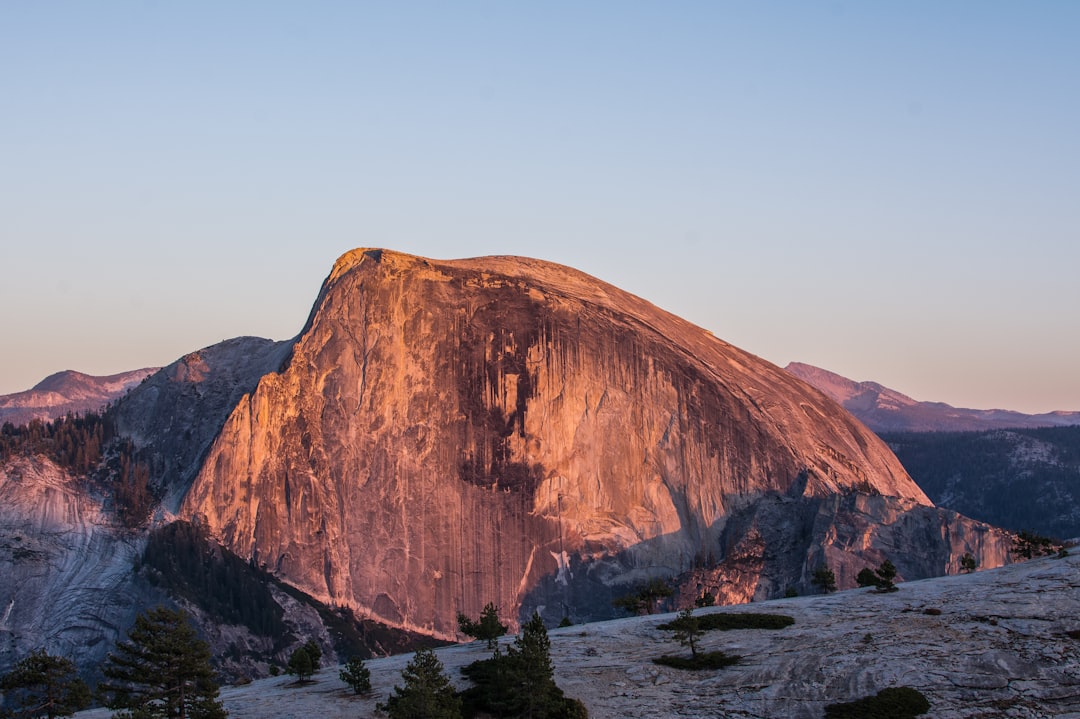 Photo of Half Dome in Yosemite National Park, golden hour, clear sky, taken with a Nikon D850 DSLR with an aperture of f/4 and ISO setting of 270 for the best balance between detail and sharpness. –ar 128:85