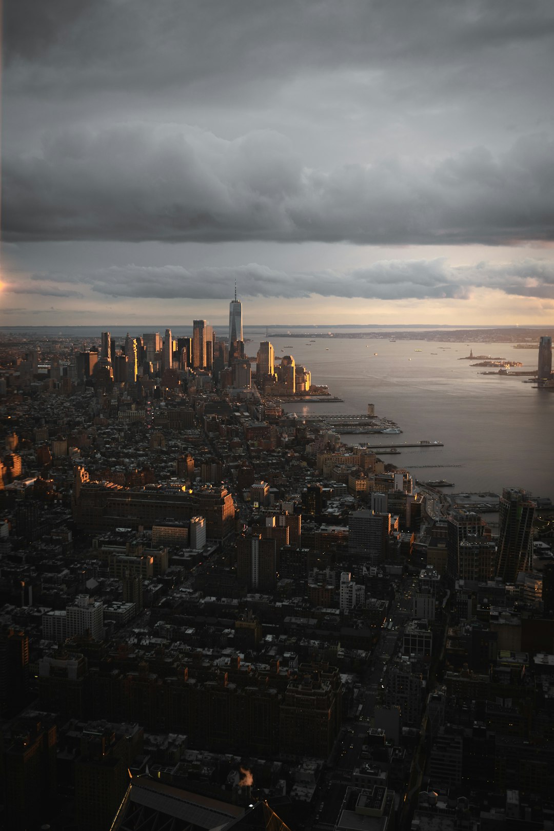 photograph of the cityscape of New York City from above, cloudy sky, golden hour, dramatic lighting, overcast, moody, cinematic, canon eos mark iii –ar 85:128