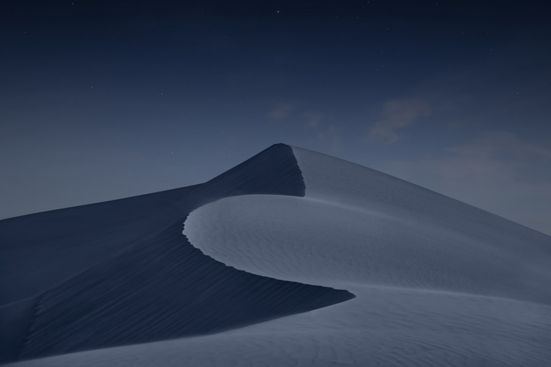 Low angle shot of the top third of an isolated sand dune at night, minimalistic, dark blue sky, high contrast, no moonlight, by [Kishin Shinoyama](https://goo.gl/search?artist%20Kishin%20Shinoyama), canon eos r5 –ar 128:85