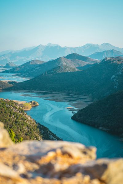 Cinematic photo of Skopje's Lake Kanderjash, view from the top overlooking the lake and surrounding mountains, blue sky, turquoise waters, surrounded by greenery, natural landscape photography, Canon EOS1D X Mark III with an EF lens for landscape photography, --ar 85:128