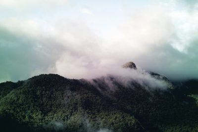 photo of mountain with clouds, drone shot, cinematic, moody, soft light, misty, rainforest --ar 128:85