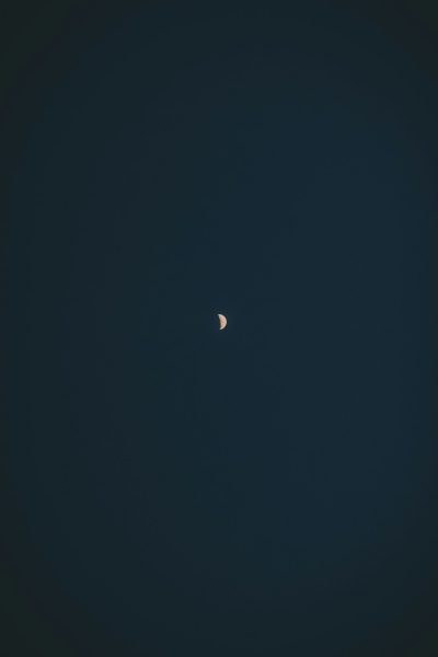 minimalist photo of the moon in a clear dark blue sky, in the style of minimalism --ar 85:128