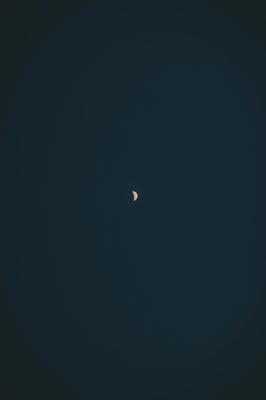 minimalist photo of the moon in a clear dark blue sky, in the style of minimalism –ar 85:128