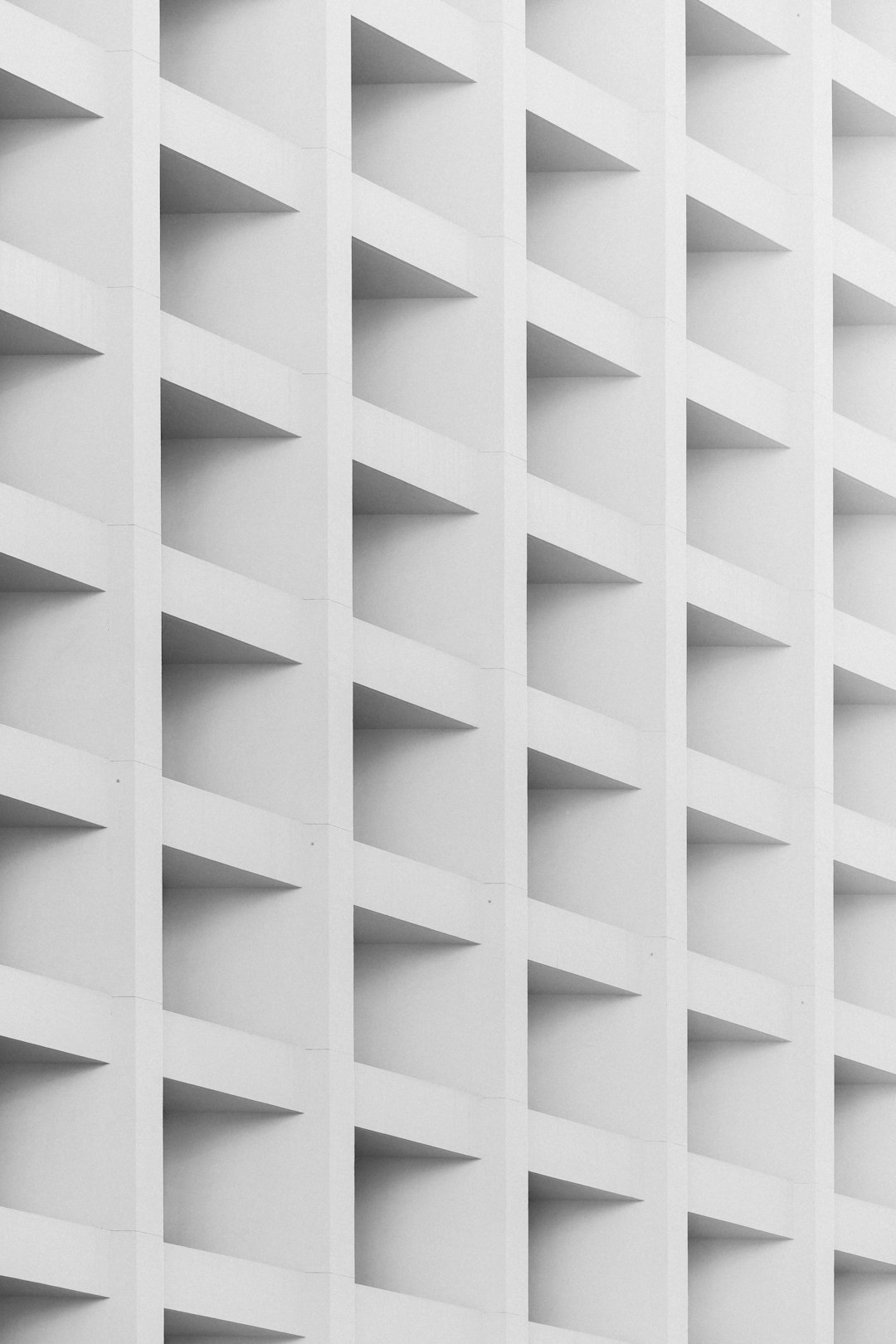 a close up of white and grey pattern, architecture photography, a grid made out of balconies on the side of an apartment building, simple, minimalistic, white background, symmetrical, architectural photograph style, high contrast, sharp focus, depth of field, geometric shapes –ar 85:128