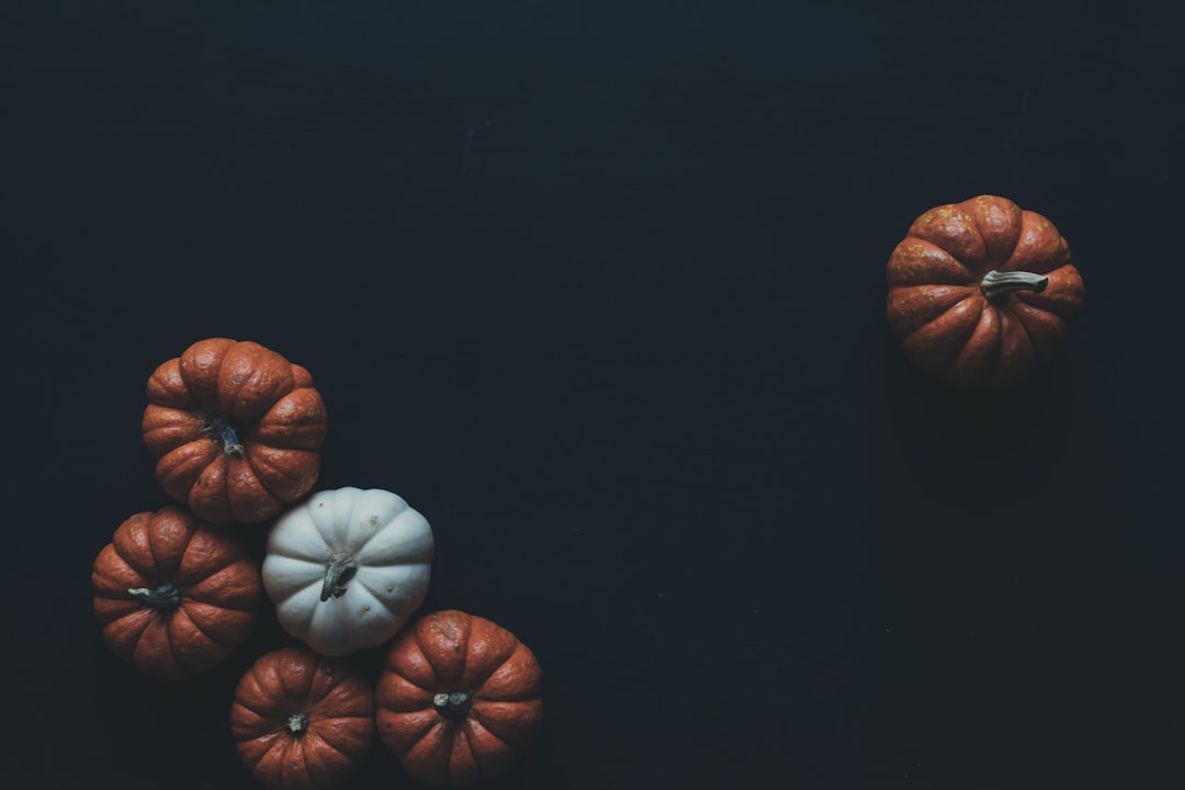 Dark background, pumpkins on the left side of the picture, minimalism, dark tones, top view, high resolution photography, Hasselblad X2D50c –ar 128:85