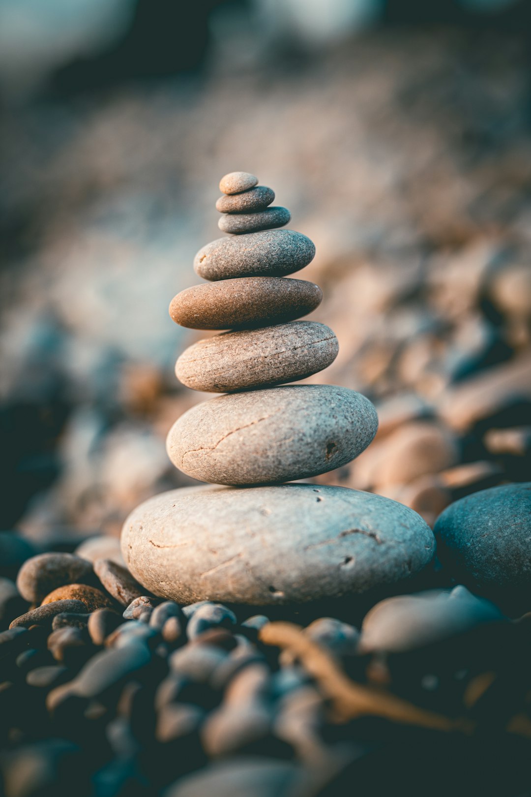 Photo of balanced stones sculpture on the beach, close up, bokeh background, unsplash photography style, –ar 85:128