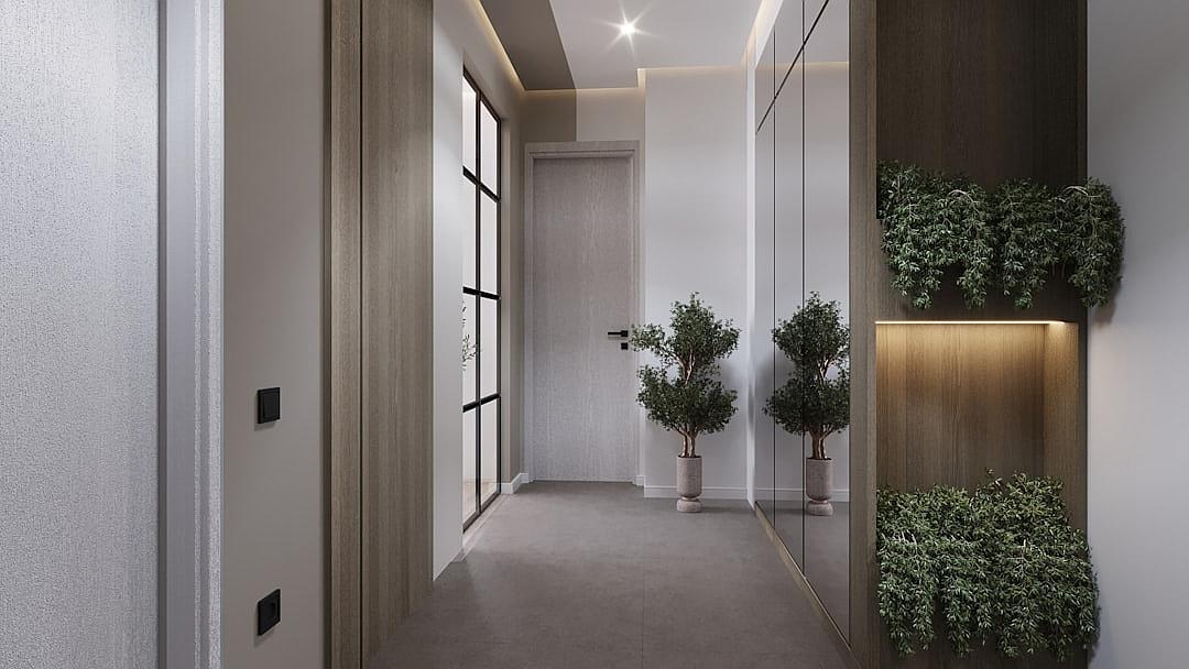 Minimalist style, hallway of the apartment with gray carpet and light wood door frames, wall panels on one side, modern lights in the ceiling. On each sides there is planters with green plants. The walls are white and clean. There’s an entrance to another room. A mirror hanging above two small vases holding trees.