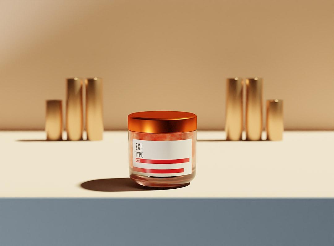 A minimalist and modern cosmetic product label design for the brand “UX Melee” in front of several cylindrical glass jars, featuring shades of brown and red with an orange cap. The background is beige, creating contrast against the bright white surface. A subtle shadow falls on one jar to add depth. High resolution photography, product photo shoot in the style of Alex Webb.