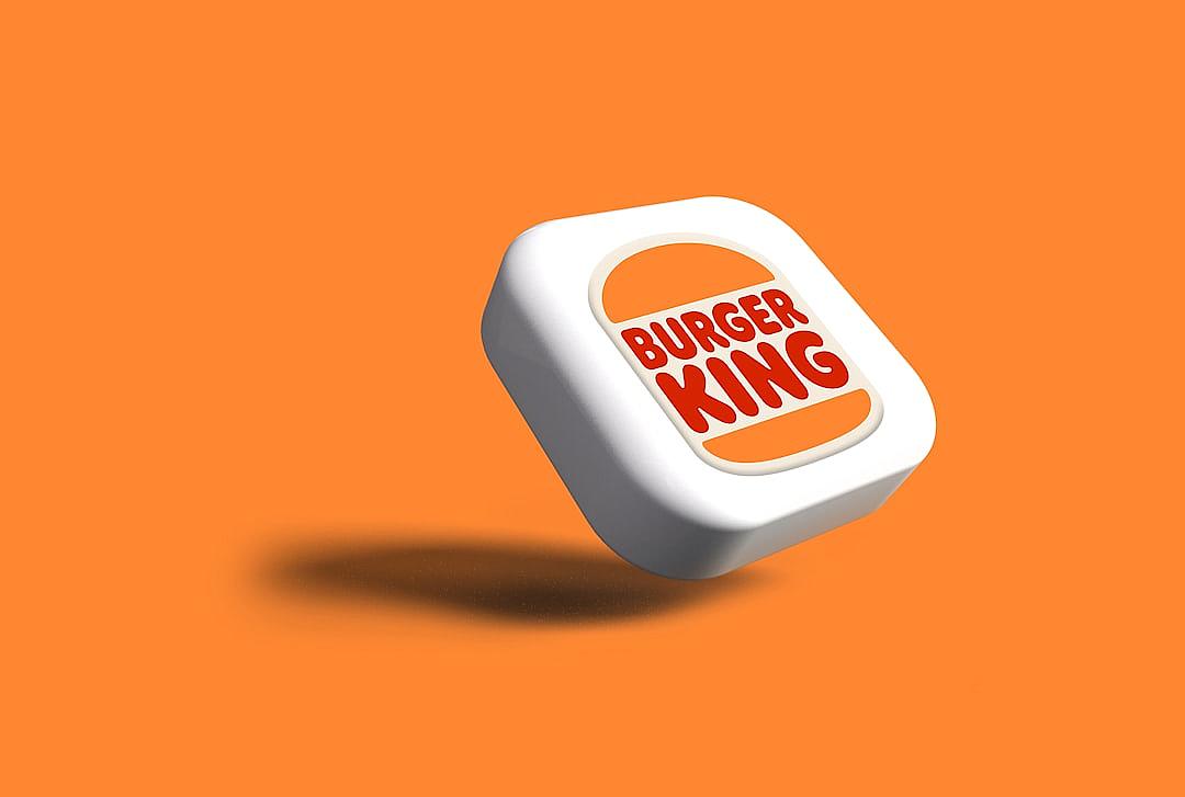 A white cube with the logo of “BURpleteese KING” on it floats in front of an orange background, in the cartoon style, logo design for burger king, 3D rendering, 2d game art, logo.