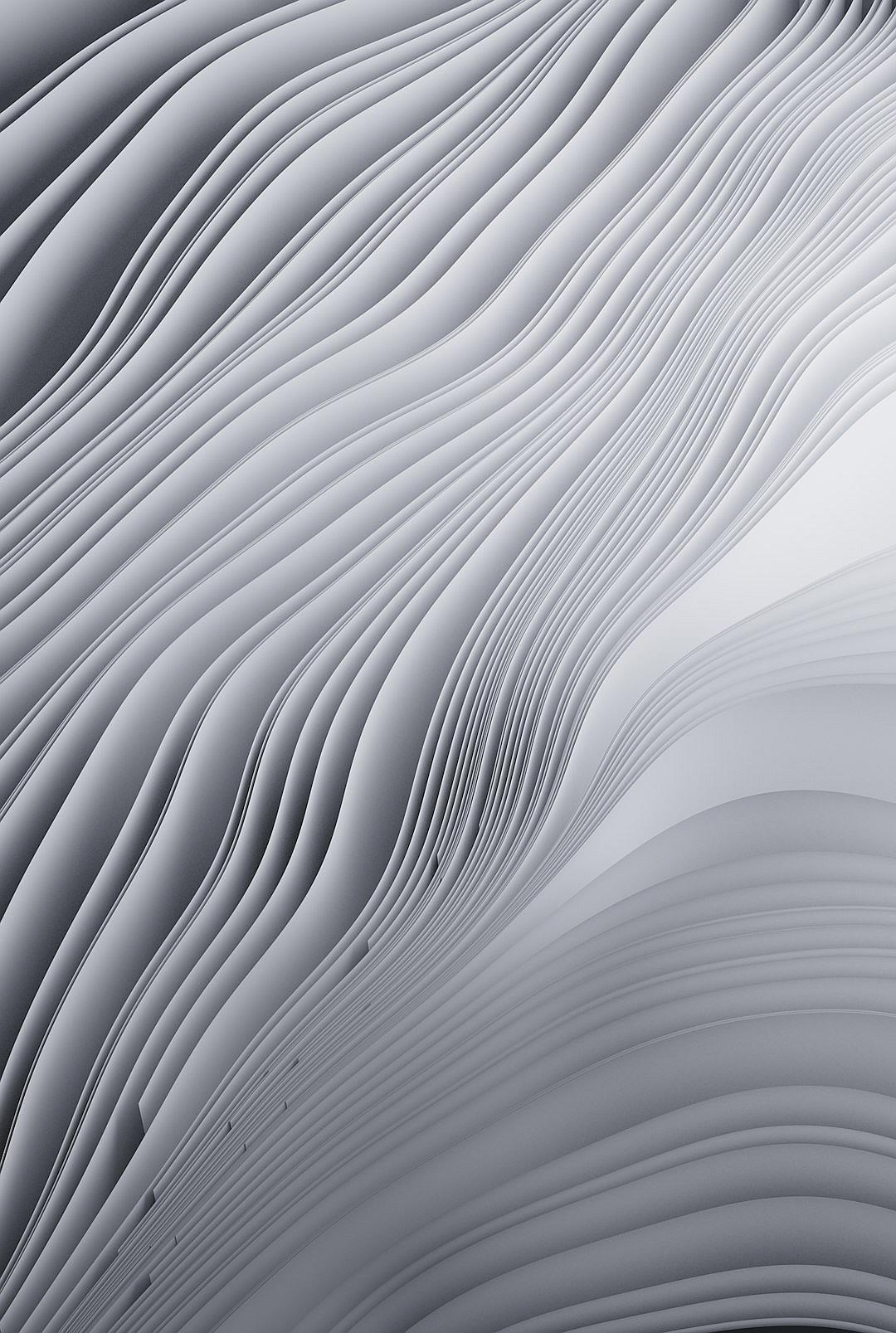 A closeup of paper waves, with soft gray tones and smooth curves, creating an abstract background. The focus is on the intricate patterns created in the style of these gentle lines, evoking calmness and tranquility in its design.