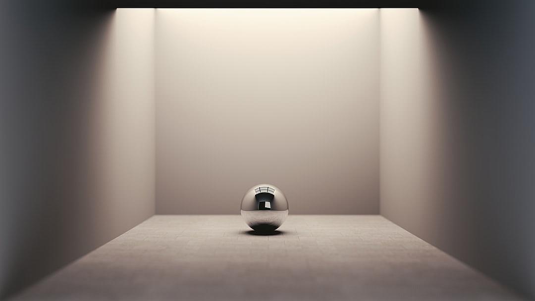 A minimalistic, ultrarealistic photograph of an eggshaped silver sphere in the center of a blank room with a single spotlight shining on it from above. The sphere is centered and the only source of light illuminates its smooth surface. It’s centered between two empty walls, creating sharp shadows that accentuate its shape. There should be no other objects or lighting elements to highlight the simplicity and focus of the scene.