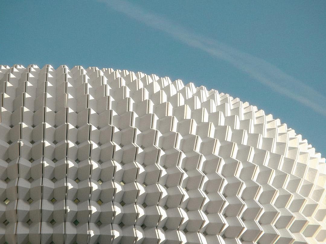 A white building with parametric texture on the roof, designed in the style of [Bjarke Ingels](https://goo.gl/search?artist%20Bjarke%20Ingels) in Seville, Spain.