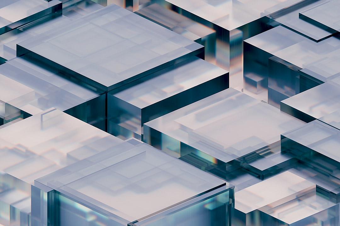 A closeup of glass cube elements, each with different size and shape, arranged in an abstract pattern on the screen. The background is a soft gradient from light blue to white, creating a futuristic feel. There is a subtle reflection off one of the cubes, adding depth to the composition. This design emphasizes technology and modernity, with the focus being placed on the intricate details of the transparent glass material.