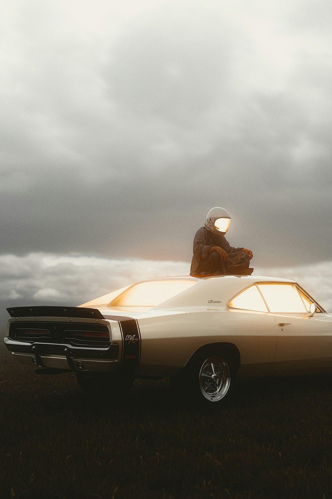 A man wearing an astronaut helmet sits on the roof of his white Dodge Harington charger car, illuminated in a soft golden light against dark grey clouds. The scene is captured in the style of cinematic with soft lighting and a muted color palette.