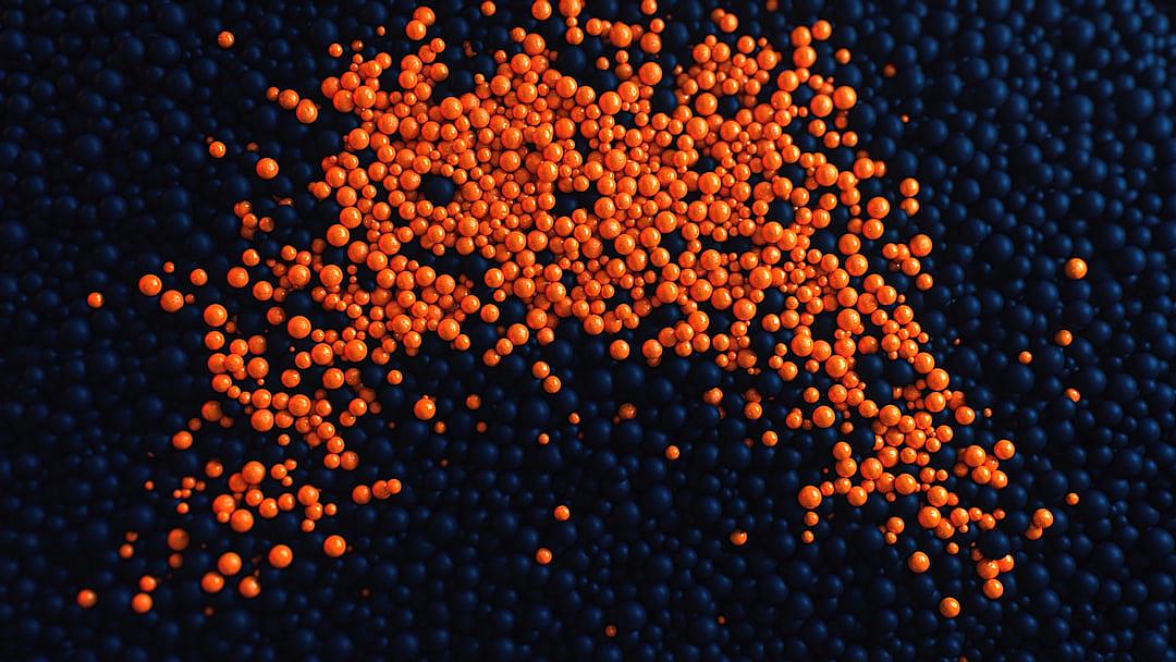 top view of orange colored small spheres on dark blue background, realistic photography style