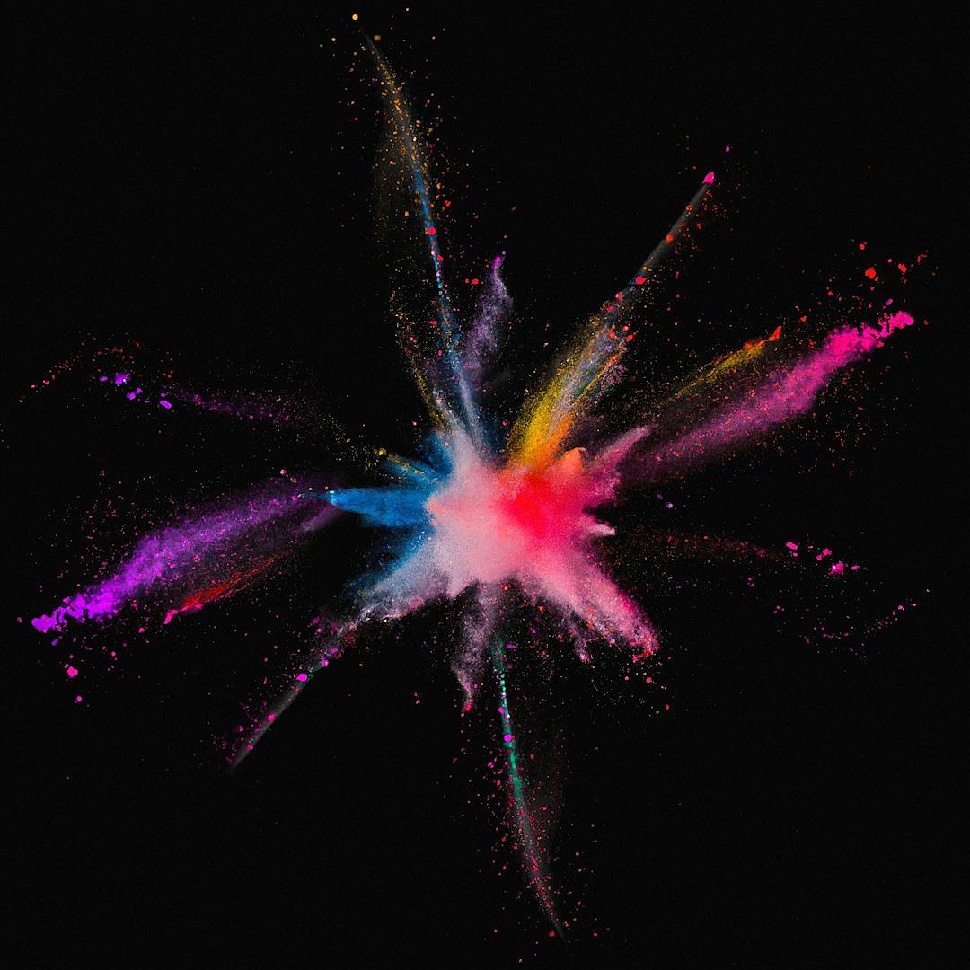 A colorful explosion of powder against black background, symbolizing creativity and energy in advertising design