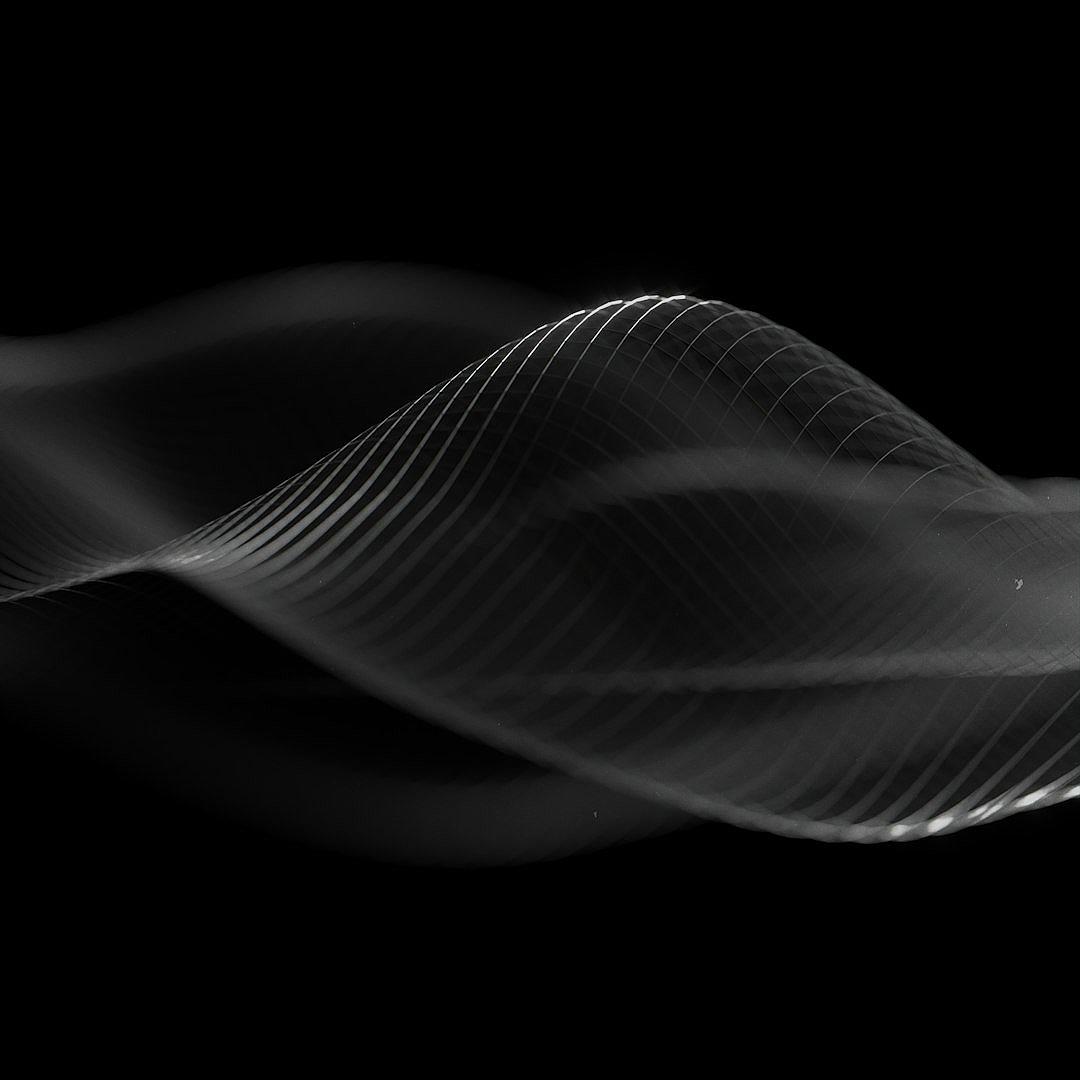 A black background with an abstract, semitransparent wavelike form of white lines and shapes. The design should have soft edges for the shape and a subtle gradient effect to give depth. It’s designed as if it were part of a motion graphics animation, but in monochrome. This can be used for a wide range of creative projects or visualizations that need a minimalist yet captivating background. The overall feel is modern and elegant.