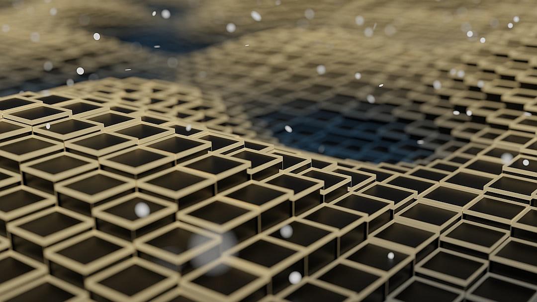 A closeup shot of the top view of an endless grid made up of small, black squares on a flat surface. The camera is positioned directly above and right behind it. In front of these cubes there’s an atmosphere with tiny particles floating in the air. A blurred background shows a brown wall with a white pattern. It creates a surreal scene that adds depth to the overall composition.