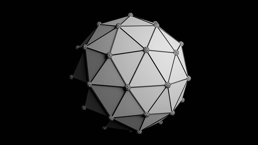 A white polygonal sphere with a geodesic structure on a black background, rendered in 3D. The sphere appears to be in the style of [Buckminster Fuller](https://goo.gl/search?artist%20Buckminster%20Fuller).