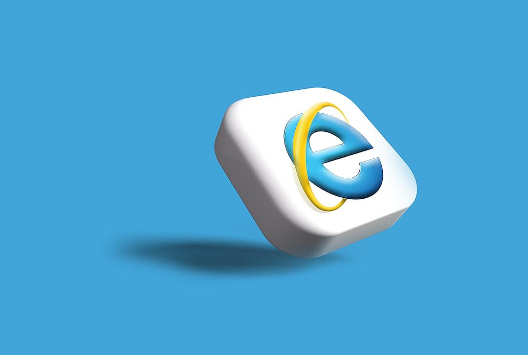 An icon of the old Tamulalle cover button in Internet Explorer on a blue background. The “E” letter is large and bold with a yellow outline, while the rest of the letters are white. There is no shadow under it. It has two colors: white for the sticker and a dark grey border.