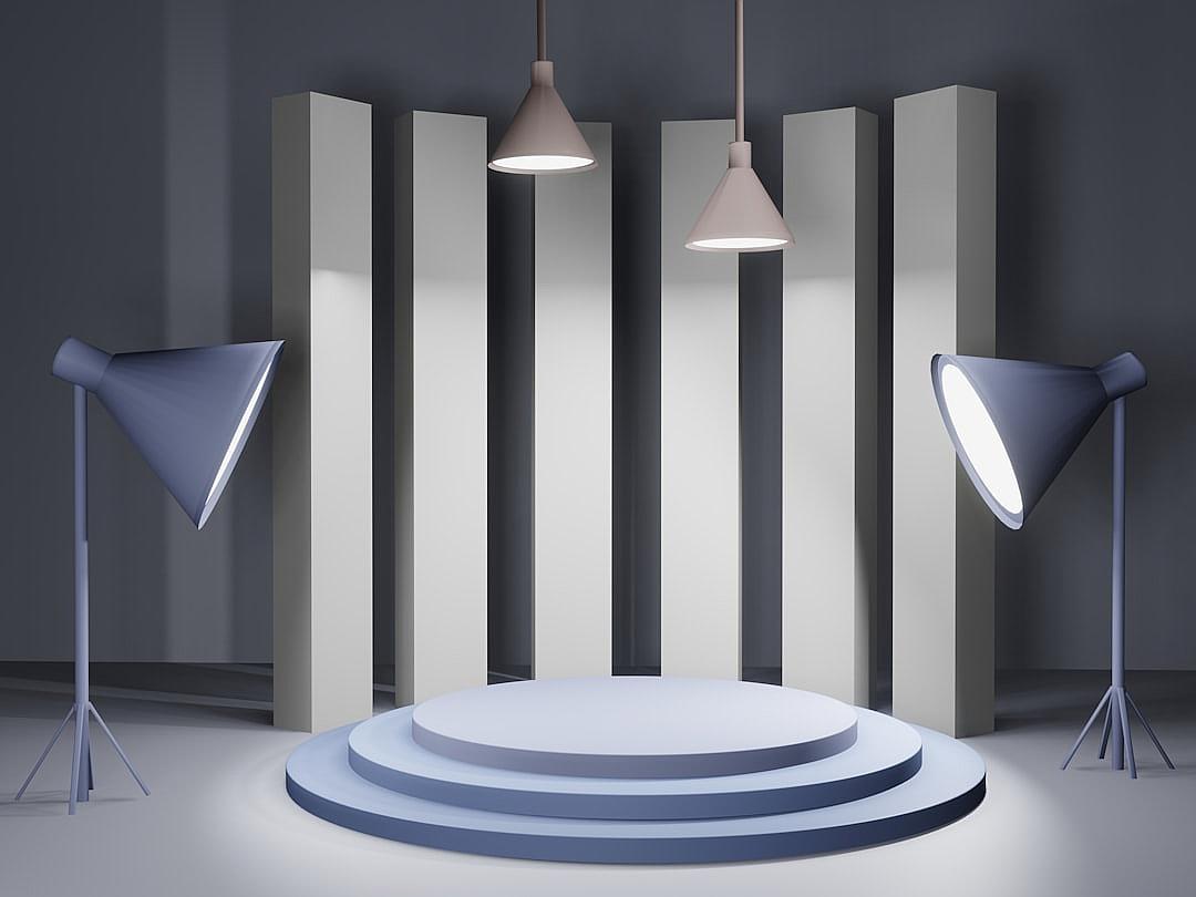 A podium with three spotlights on each side, arranged in an asymmetrical pattern. The background is a simple grey wall with vertical stripes of different shades of blue and white. There is no text or product displayed on the stage, creating a minimalist yet elegant setting for showcasing products. The lighting creates sharp shadows that accentuate the contours of the round surface at its center, giving it a sense of depth and focus.