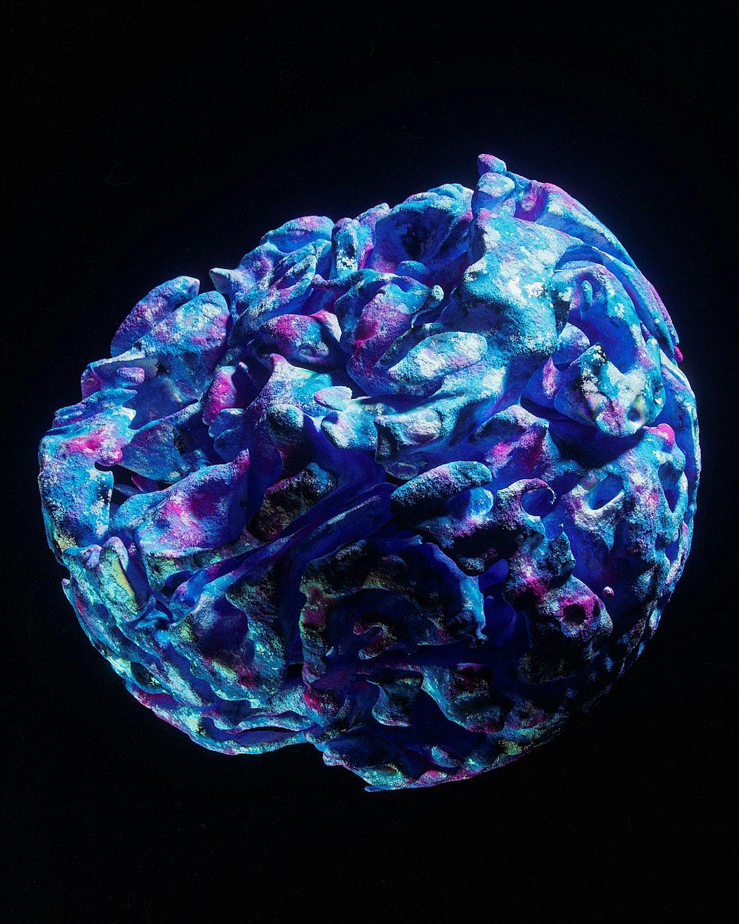 blue and purple coral sphere with bioluminescent patterns on a black background, hyper realistic photography in the style of black background