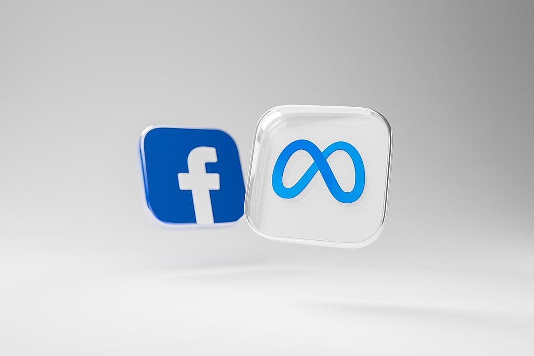 3D rendering of two social media logos facing each other, the logo on the left is for Facebook and is blue in color with a white background; The icon on the right side symbolizes infinite possibilities and is made in the style of an infinity sign and dust flying around it, the icon has a glass texture and is white with a blue outline, floating on a plain solid gray background, with no shadows.