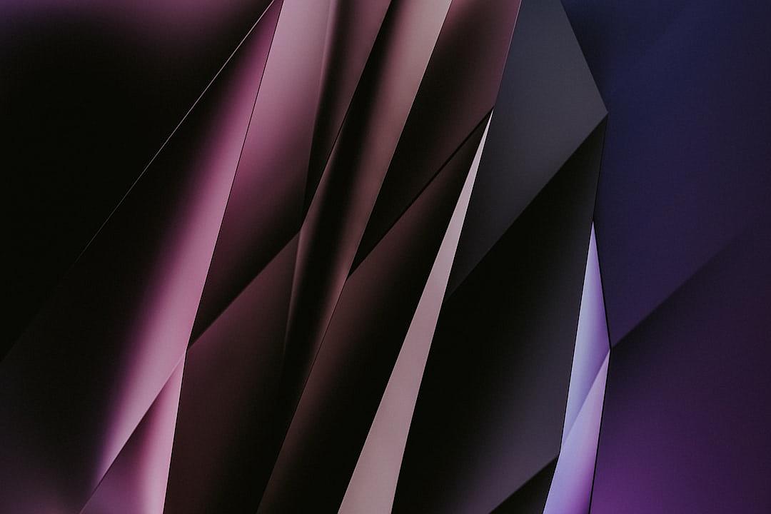 A minimalistic background design with purple and black hues, featuring abstract shapes that resemble folded paper or geometry in the style of origami.