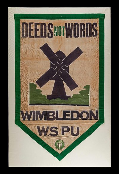 vintage cloth banner with windmill and text "DEEDS NOT Picks" in green, cream white background, vintage wמכרinswoodide football club emblem on the border of shield, black outline of logo with lettering "WDan shown as crossed by an scRet getDefault Football team name written in cursive letters under all that is saying Wiederod football player shown as cross hatching , "GOOD ENLabel shows logo "Battle ", style raw, png