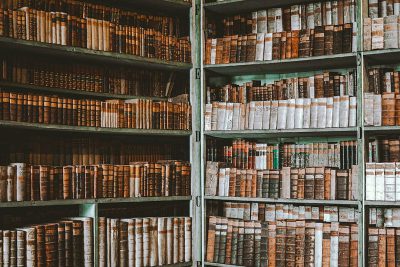 A vintage library filled with shelves of old books, representing the wisdom and knowledge that can be Brewing up ideas for 'The Bookish Master's recording course' through video content creation using artificial intelligence technology.