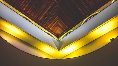 A close-up photo of a ceiling with dark wood and yellow neon lighting, in a V shape design, interior architecture photography in the style of Architectural Digest quality picture.