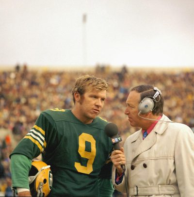 green bay packers football player in green and yellow jersey being interviewed by an American television reporter on the field of the american Super Bowl, vintage photo, 70s style, retrofuturism in the style of 70s