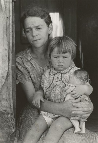 A mother with her toddler and baby, the child has sad face expression in their arms. Photo by [Dorothea Lange](https://goo.gl/search?artist%20Dorothea%20Lange) . Black & white photo