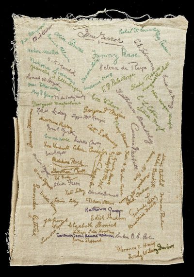 A linen handfocus embroidered piece of cloth with many different people's name and signature on it, green ink text,