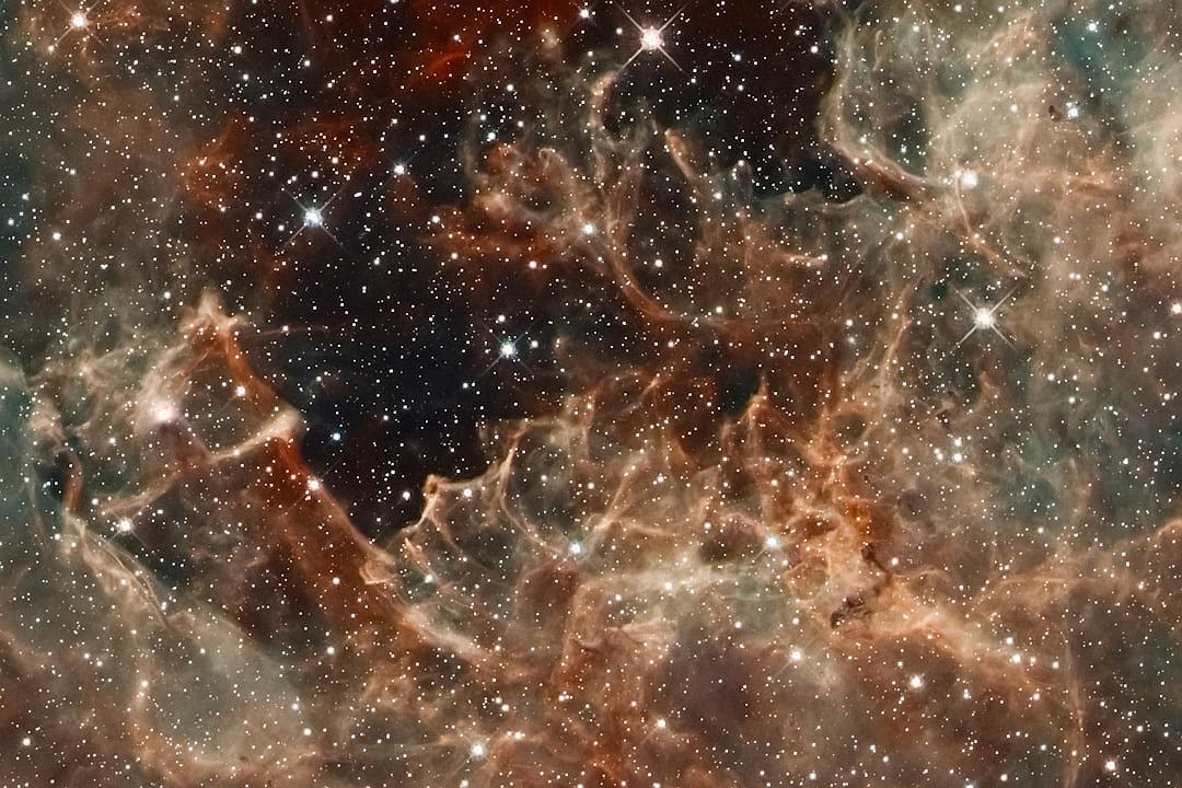 A closeup of the James Webb Space Telescope’s first light, capturing details in nebula clouds and distant stars. The focus is on intricate patterns within gas cloud formations, with highlights showing cosmic dust particles. In hues of reds, oranges, and blues, it captures celestial beauty in its purest form. This high-resolution photograph reflects a blend between realism and fantasy elements in the style of Hubble’s images. It evokes wonder at the vastness of space.