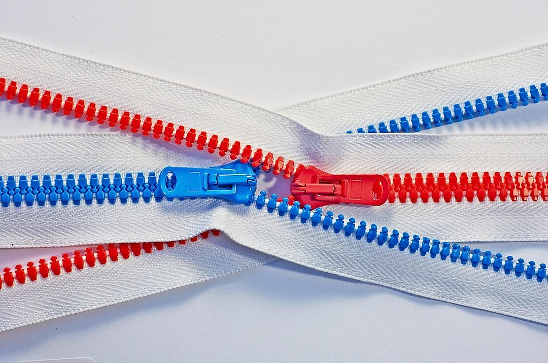 Closeup of a zipper with red, blue and white zippers on a plain background, symbolizing US politics. This was the cover art stock photo contest winner, with high resolution photography in the style of high quality.