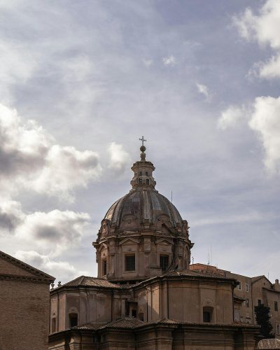 A photo of the dome of San bassansen, Rome, seen from afar, cloudy sky, natural light, canon eos r5