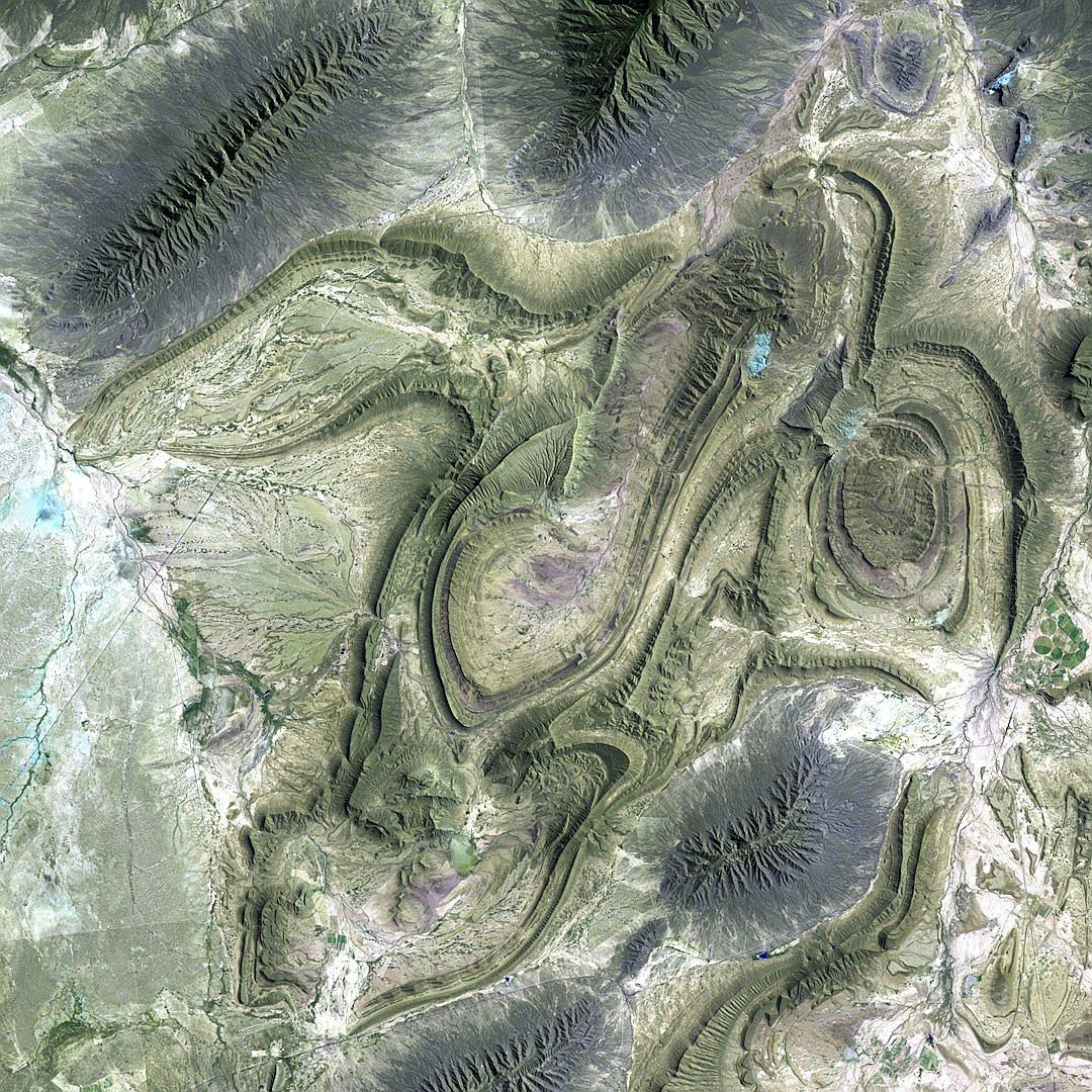 a satellite view of the T电池átin F slope in San Jose del Carupari, squares and organic shapes, top down view, alien mining complex with large earthworks and stone arches, highly detailed