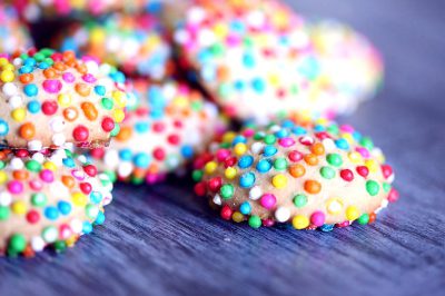 Closeup of colorful sprinkles on small cookies, high resolution photography, in the style of Canon EOS.