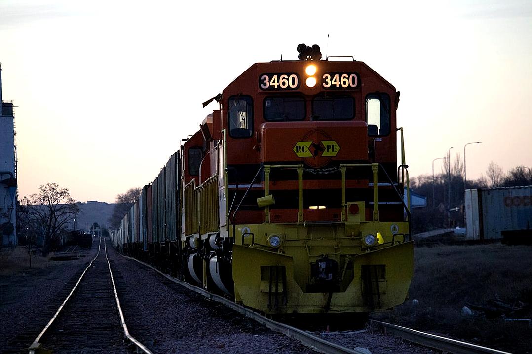 A photo of an orange and yellow freight train with the number “3460” written on it, at dusk in the midwest. Shot in the style of ARRIFLEX 25 BL Camera Canon K7 prime lens 8mm.