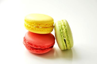 3 macarons, red, yellow and green on a white background, food photography, closeup in the style of by an artist.