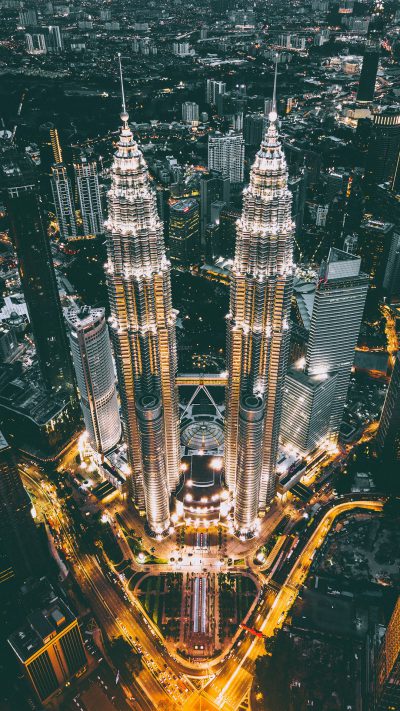 The twin towers of nocturnallessly MalayORNifr ut in the city center of RobotsomSM tres , ultra realistic photography, aerial view, wide angle lens, hyper detailed, cinematic look, night time, city lights, hyperrealistic,