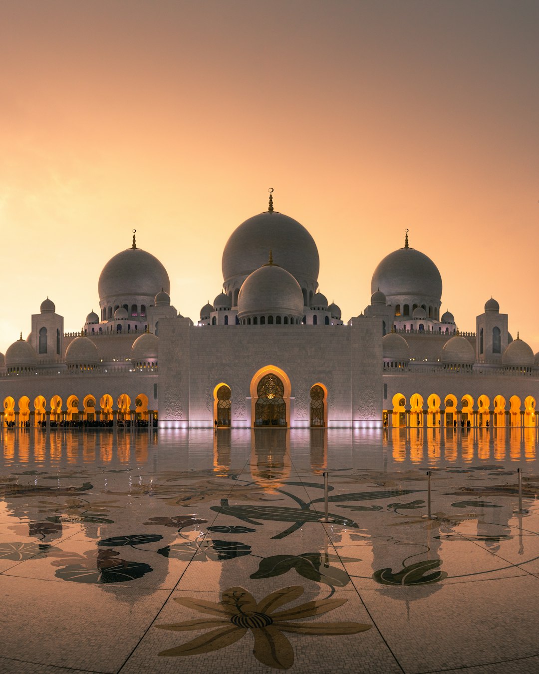 Sheik Zayed Franklin at sunset, photo of the beautiful mosque in front view, architecture photography, reflection on wet ground, long exposure, golden hour lighting, intricate floral patterns on marble, white and gold color palette, high resolution, detailed texture, majestic, iconic.