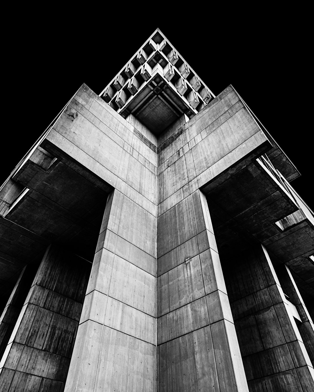 Black and white photography of the tower with triangular columns, brutalist architecture in the style of concrete material, shot from below, perspective with minimal repeated words or Chinese characters and grammar and spelling corrected. –ar 51:64