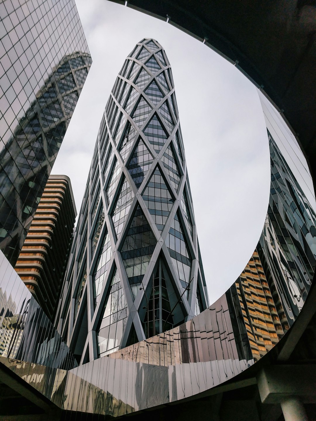 A fish eye lens photo of the famous glass and steel skyscraper in Hong Kong, surrounded by other buildings, reflection photography in the style of architectural minimalism, shot on Sony Alpha A7 III. –ar 3:4