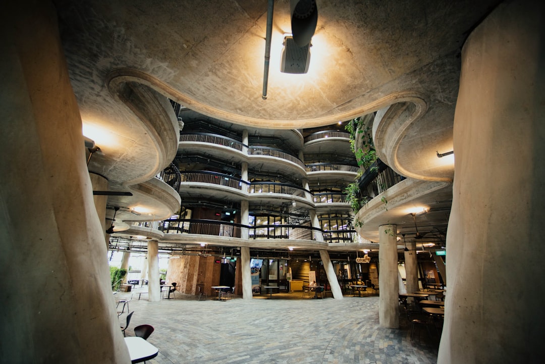 The interior of the fivestory building is made in an organic style, with curved walls and ceilings, designed by Tadao AndDocuments,,in of concrete material, adorned with plant elements, featuring multiple levels that lead to each other. The space features spiral staircases leading from floortostaircase. It has tables for eating inside as well as chairs for sitting on. In front of it lies some entrance doors. This unique structure creates a feeling of being inside nature. Inside there’s also cafe serving coffee, where people can sit down and drink their drinks while looking at the architecture. –ar 128:85