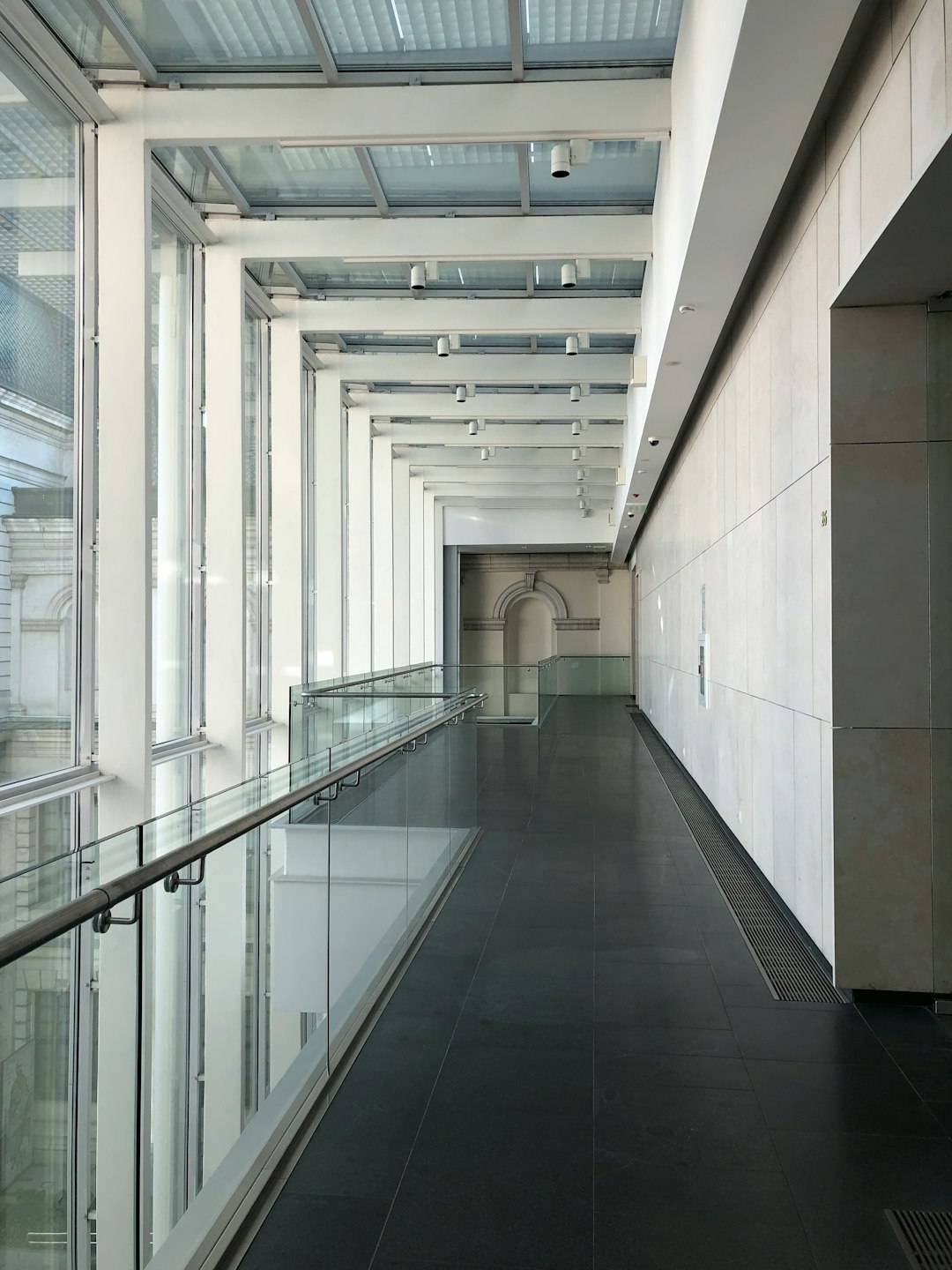 modern museum interior, white walls with black floor tiles and glass balcony railings, long corridor, large space in the style of various artists. –ar 3:4