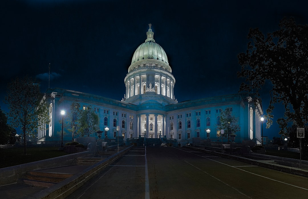 photograph of the state capital building in Madison, wisconsin, at nighttime, with blue lighting, using a centered composition and wide angle lens.